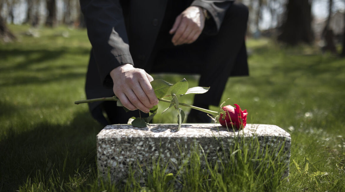 man-bringing-rose-tombstone-cemetery-1170x650